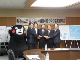 左からくまモン、西村益城町長、小嶋サントリーホールディングス株式会社専務、知事、日置西原村長、濱田林業公社副理事長 左からくまモン、西村益城町長、小嶋サントリーホールディングス株式会社専務、知事、日置西原村長、濱田林業公社副理事長